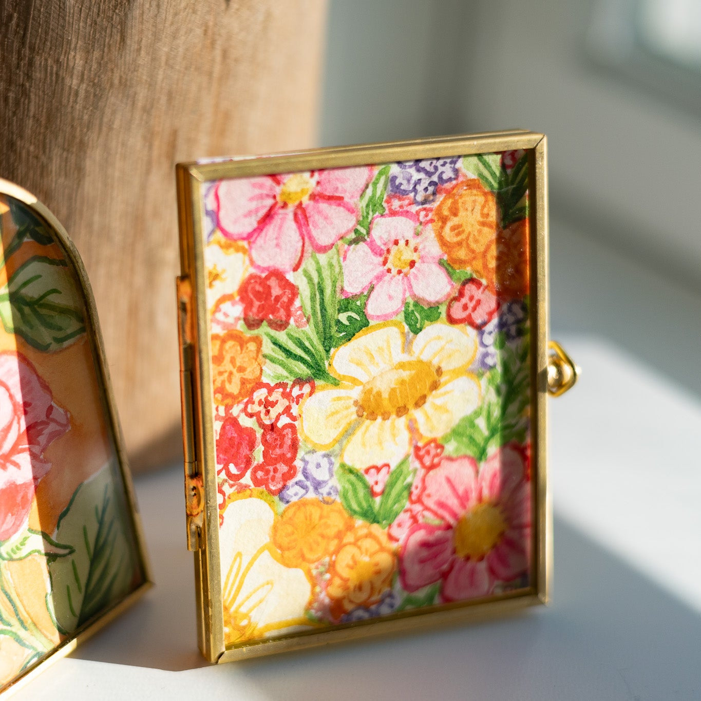Decorative gold frame with floral painting on a desk