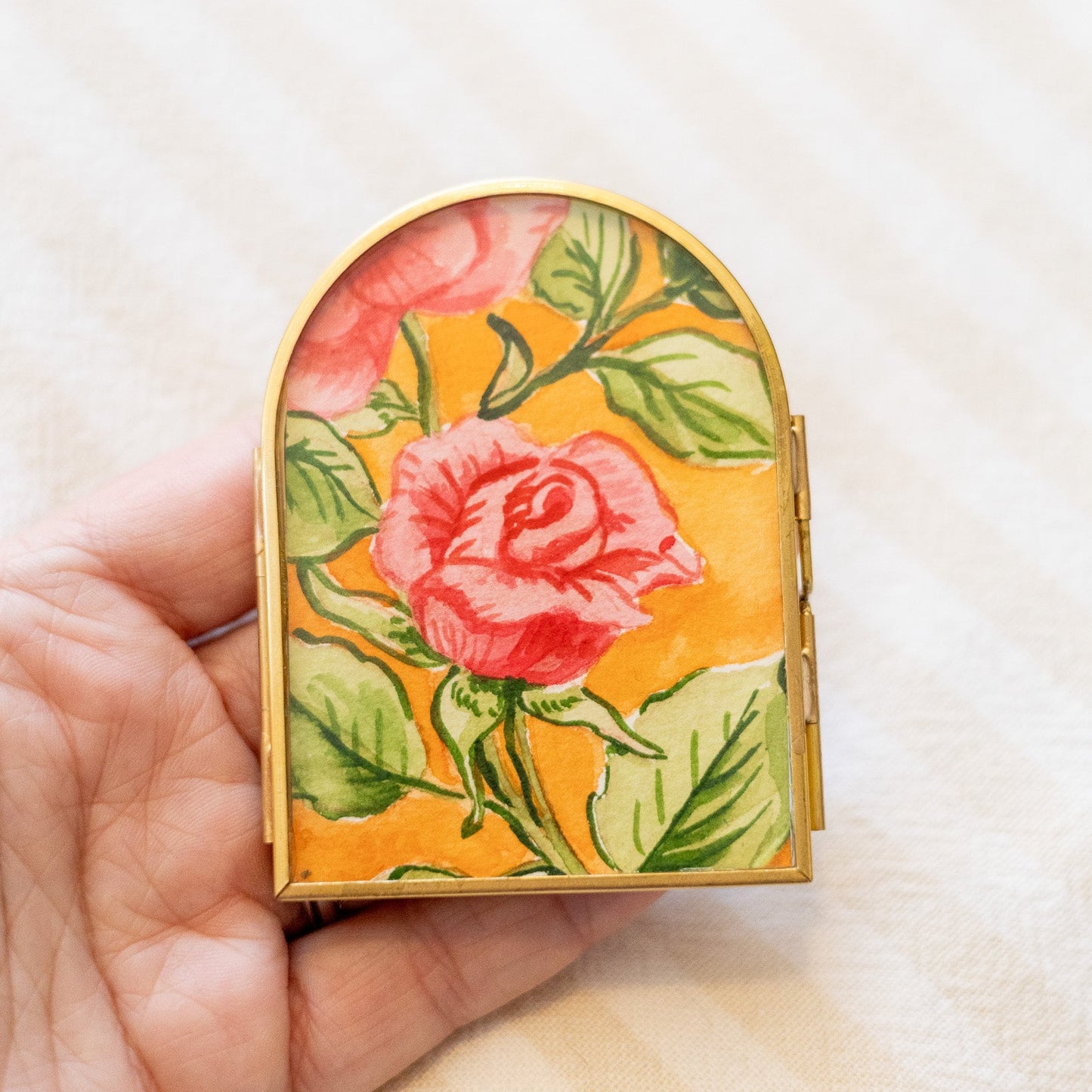 Decorative arch frame with floral painting in a hand