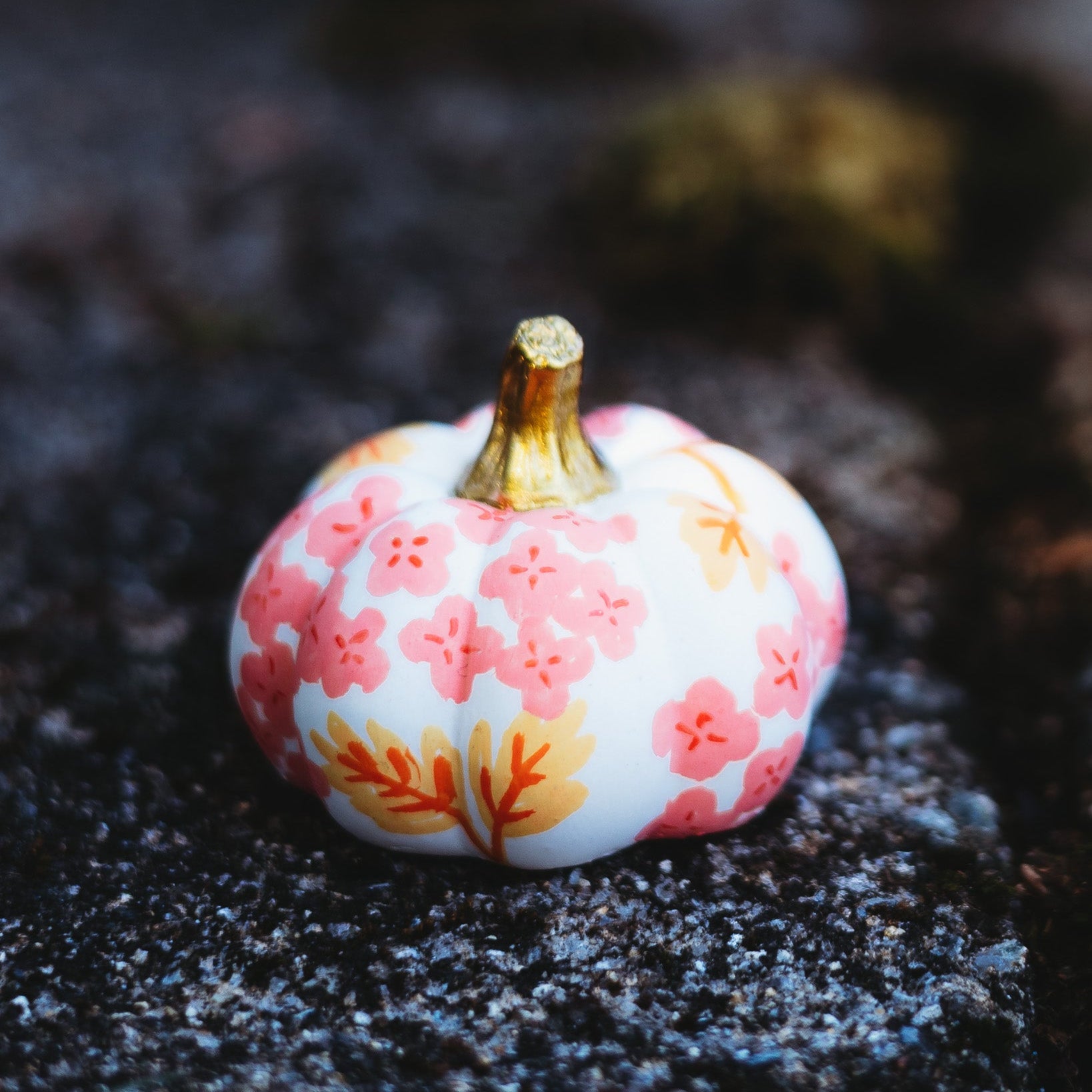 Decorative pumpkin with floral pattern on a dark surface