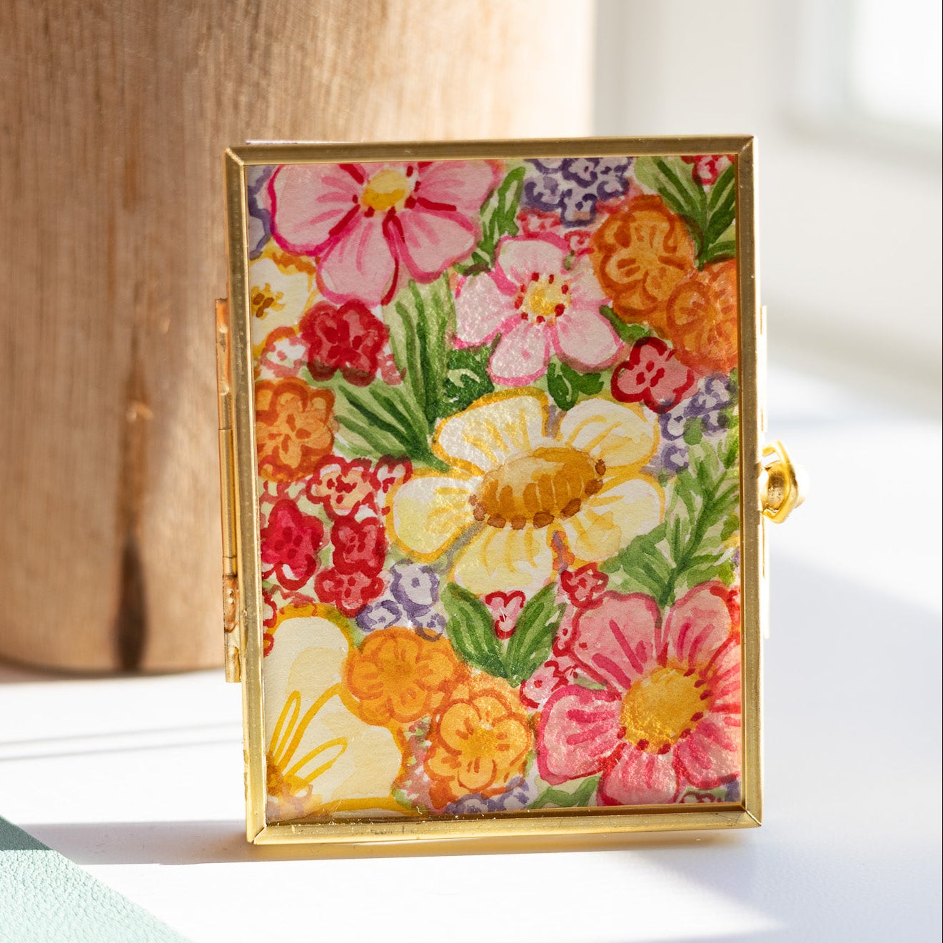 Decorative gold frame with floral painting on a desk