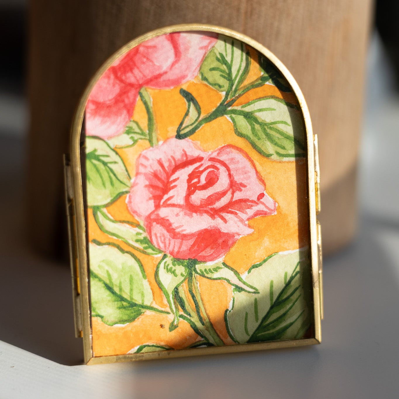 Decorative arch frame with floral painting on a desk