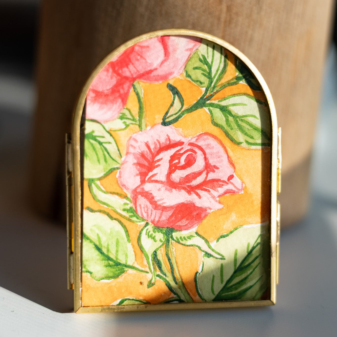 Decorative arch frame with floral painting on a desk